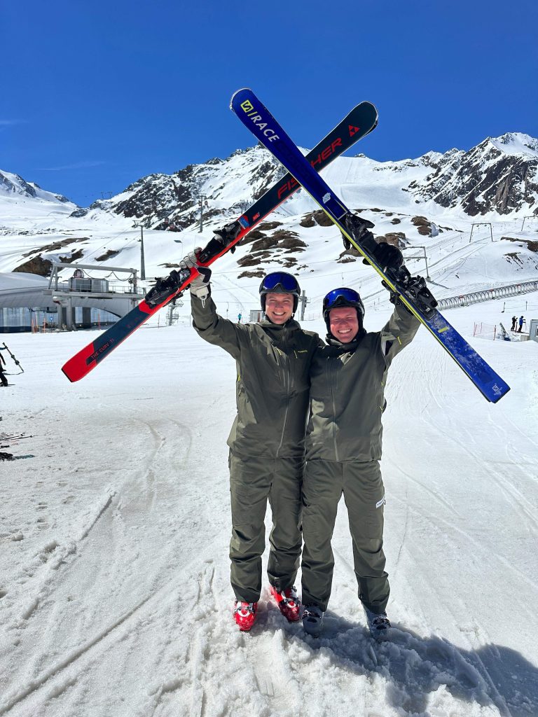 Zwei Skilehrer des SCA halten ihre Ski gekreuzt in die Höhe