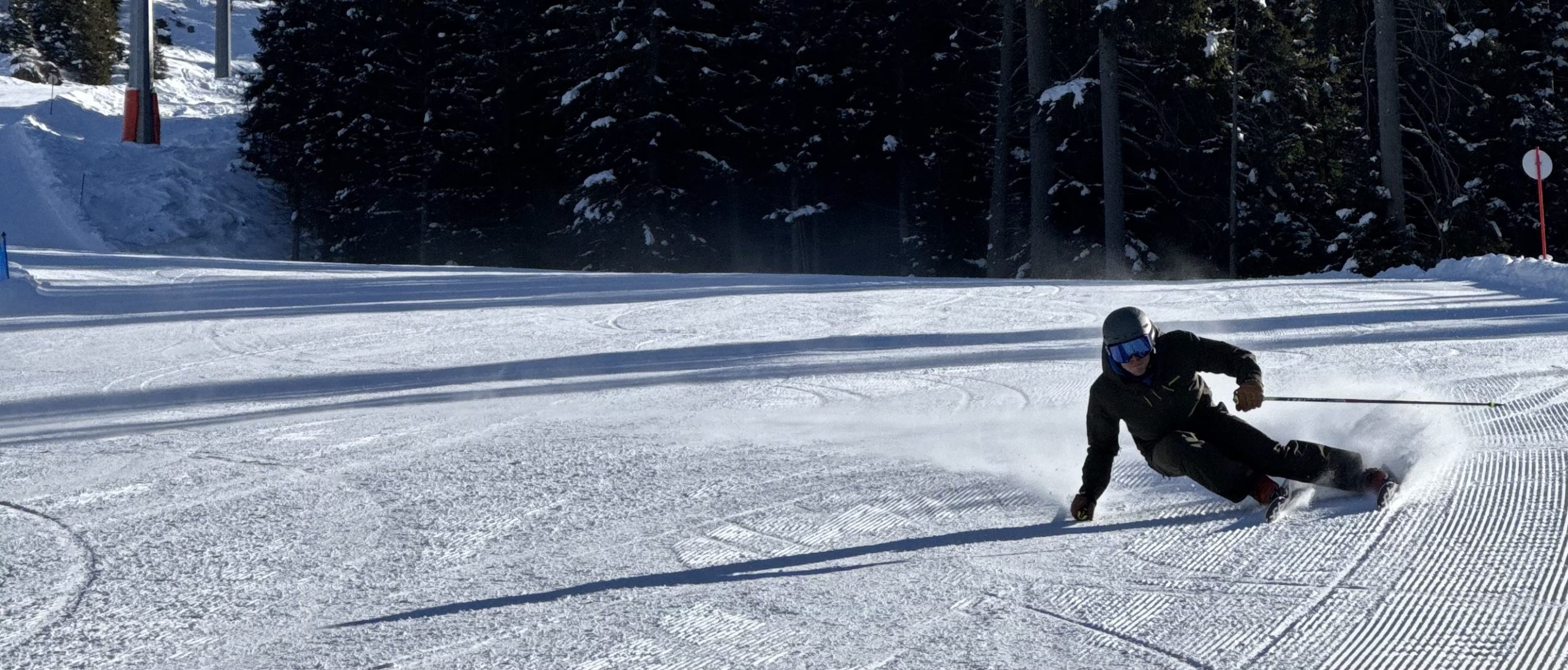 Skifahrer in voller Fahrt auf präparierter Piste